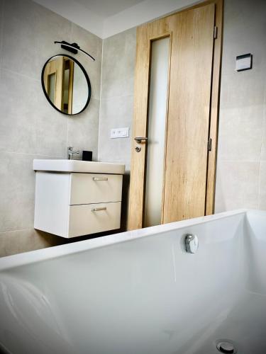 La salle de bains est pourvue d'un lavabo blanc et d'un miroir. dans l'établissement Chaty Čapák, à Velké Losiny