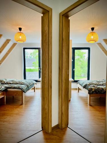a room with two beds and two windows at Chaty Čapák in Velké Losiny