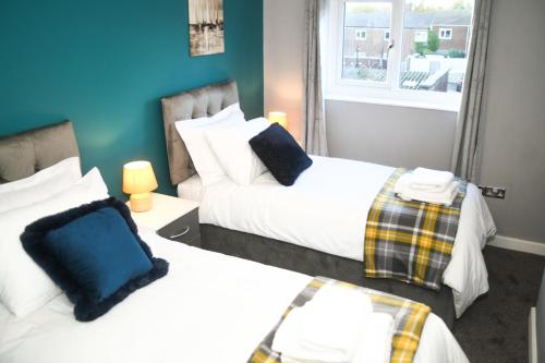 Tempat tidur dalam kamar di 2ndHomeStays- Willenhall-A Serene 3 Bed House with a Garden View-Suitable for Contractors and Families-Sleeps 9 - 7 mins to J10 M6 and 21 mins to Birmingham