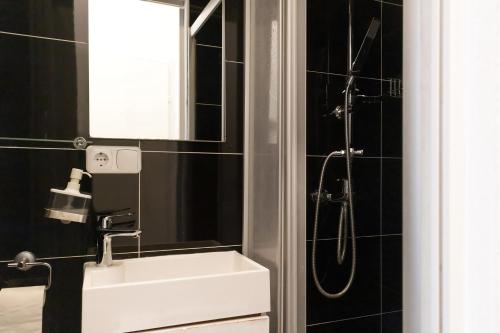een badkamer met een witte wastafel en een douche bij Modern 1BR Apart- Suitable for Longstays in Wenen