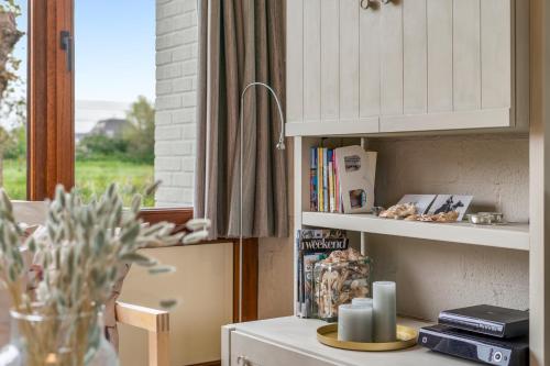 eine Küche mit einer Theke mit einem Bücherregal und einem Fenster in der Unterkunft Zeeanemoon - Holiday home for 6 persons in Middelkerke