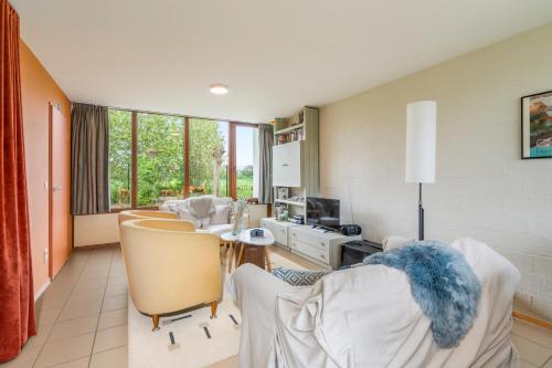 ein Wohnzimmer mit Stühlen und einem Tisch mit einem TV in der Unterkunft Zeeanemoon - Holiday home for 6 persons in Middelkerke