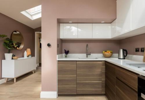 a kitchen with white cabinets and a sink at Fallow Cottage in Lyndhurst