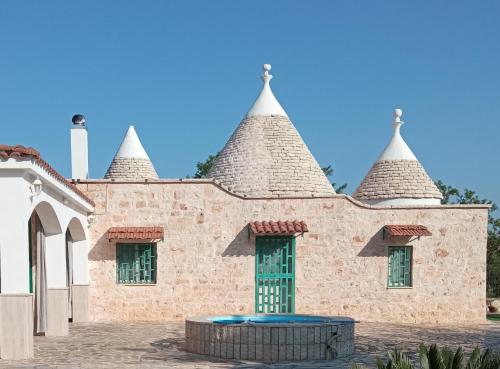 budynek z trzema wieżami na górze w obiekcie Villa Il Leccio - Trulli w mieście Cisternino