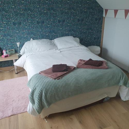 - un lit avec 2 serviettes dans une chambre dans l'établissement chambres dans maison à 15min du circuit des 24h du MANS, à Roézé-sur-Sarthe