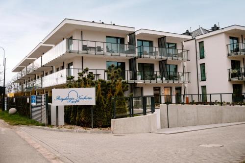 an apartment building with a sign in front of it at Nadmorski Loft Rezydencja Niechorze 116 plaża ogród in Niechorze