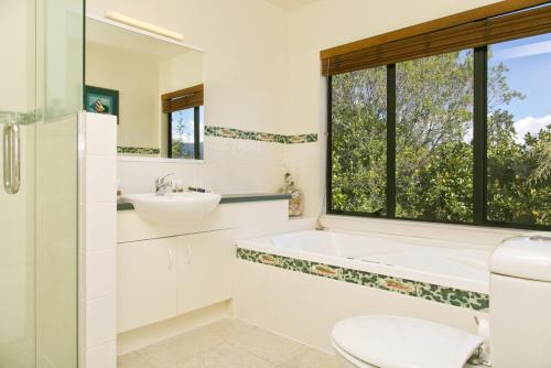 bagno con vasca, lavandino e finestra di Tongariro Lodge a Turangi