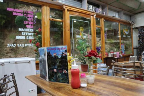 uma mesa de madeira com um livro sobre ele em um restaurante em Barot , Waterfall Camps and Domes I Best seller em Mandi
