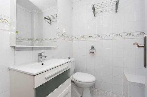 a white bathroom with a toilet and a sink at CH Buganvillas Ciudad Quesada in Ciudad Quesada