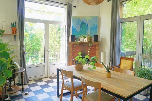 a dining room with a wooden table and chairs at Green Home in La Roche-Guyon