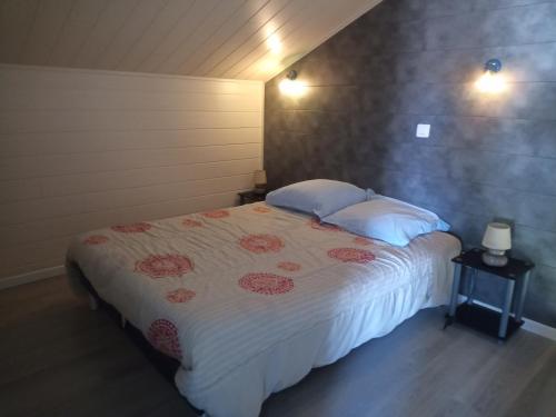 een slaapkamer met een groot bed met 2 kussens bij M. Clemenceau - Les Maisonnettes De La Maneliére in La Flocellière
