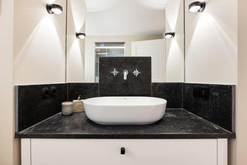a bathroom with a white sink and a mirror at Ferienhaus Miarwuefki in Rantum