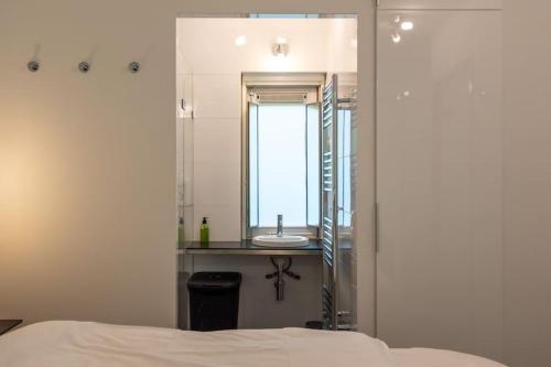 La salle de bains est pourvue d'un lavabo et d'un miroir. dans l'établissement Heerlijk vakantiehuisje op rustig Natuurpark, à Otterlo
