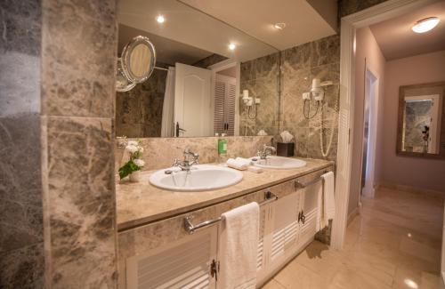 łazienka z 2 umywalkami i dużym lustrem w obiekcie Ona Lomas Village - La Manga Club w mieście La Manga del Mar Menor