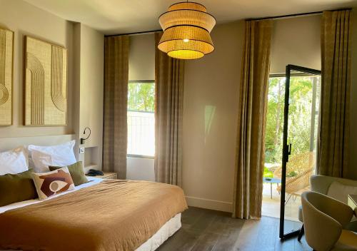 a bedroom with a bed and a large window at Les Lodges Sainte-Victoire Hotel & Spa in Aix-en-Provence