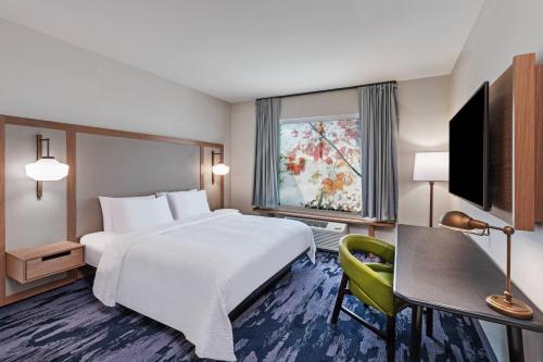 ein Hotelzimmer mit einem Bett, einem Schreibtisch und einem TV in der Unterkunft Fairfield by Marriott Inn & Suites Aberdeen, SD in Aberdeen