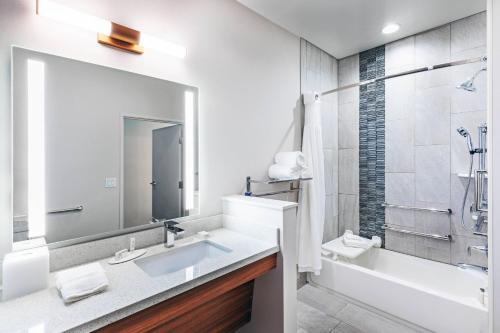 uma casa de banho com um lavatório, uma banheira e um espelho. em Fairfield by Marriott Inn & Suites Aberdeen, SD em Aberdeen