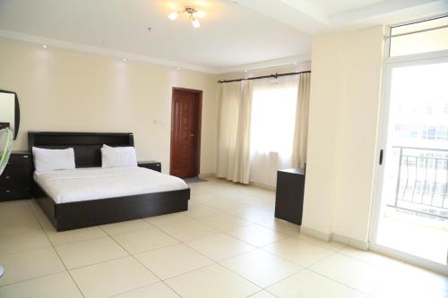 1 dormitorio con cama y ventana grande en Executive Suites, en Kigali