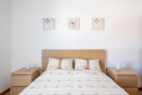 a bedroom with a bed with three pictures on the wall at Casa Alto da Serra Sesimbra in Sesimbra