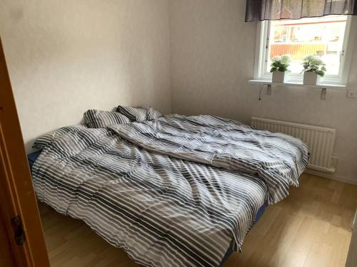 an unmade bed in a bedroom with a window at Stuga i vassemåla in Vimmerby