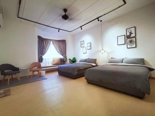 um quarto com 2 camas, uma cadeira e uma janela em S&G Homestay - JB@Permas Jaya em Johor Bahru