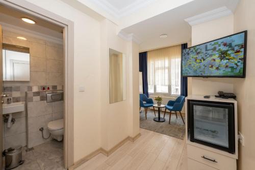 a bathroom with a toilet and a tv in a room at Hotel Grand İstanbul in Istanbul