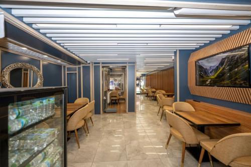 Hotel Grand İstanbul في إسطنبول: غرفة طعام بجدران زرقاء وطاولات وكراسي