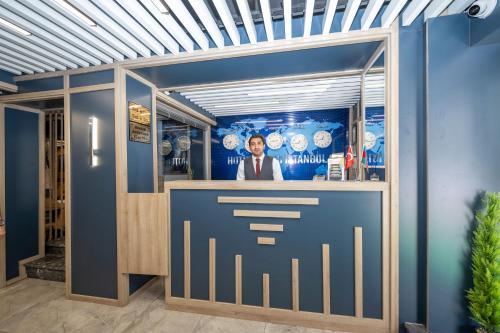 a man standing at a bar in a blue room at Hotel Grand İstanbul in Istanbul
