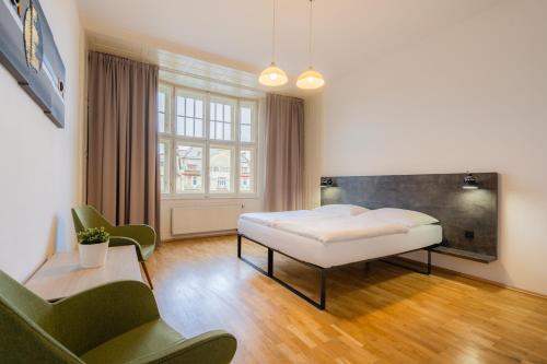 a bedroom with a bed and a couch and a window at EA ApartHotel Melantrich in Prague