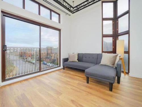 sala de estar con sofá y ventana grande en Baltic Dockside Apartment, Free Parking, en Liverpool