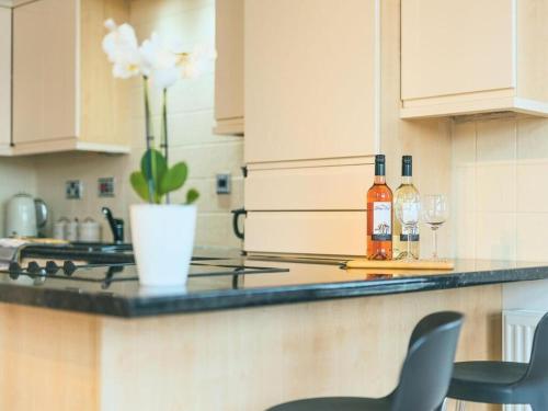 una cocina con barra y 2 botellas de vino en Baltic Dockside Apartment, Free Parking, en Liverpool