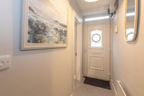 a hallway with a white door and a painting at Historic Hideaway Waterford City in Waterford