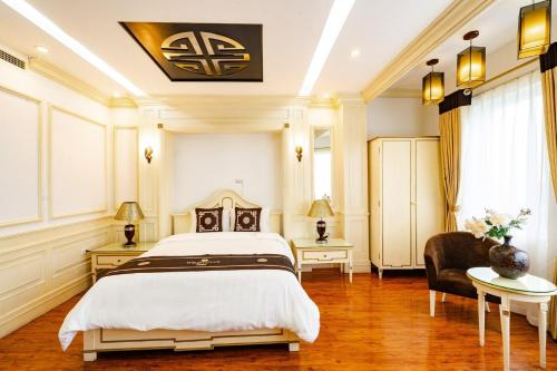 a bedroom with a large bed and a chair at Wild Lotus Hotel Apartment 2 in Hanoi