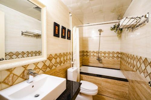 a bathroom with a sink and a toilet and a mirror at Wild Lotus Hotel Apartment 2 in Hanoi