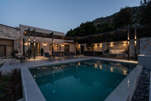 a swimming pool in front of a house at Eumelia Iconic Villa, with Heated Pool & Whirlpool, By ThinkVilla in Asigonía