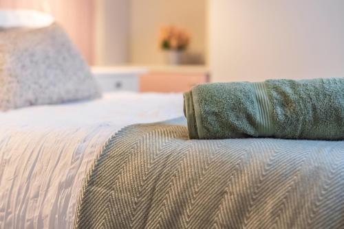 a bed with a green blanket on top of it at Historic Hideaway Waterford City in Waterford