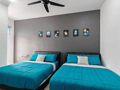 una camera con 2 letti blu e un ventilatore a soffitto di W17WarmStay@GoldenHills a Brinchang