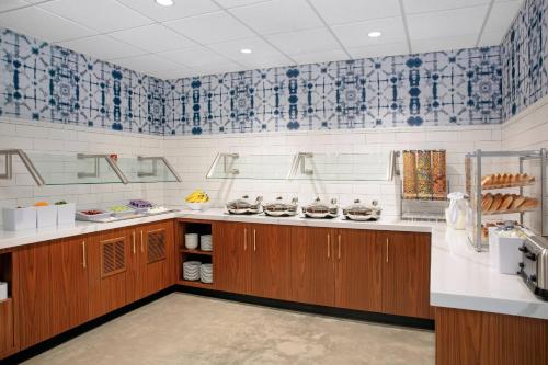 a kitchen with wooden cabinets and blue and white tiles at Residence Inn by Marriott Norwalk in Norwalk