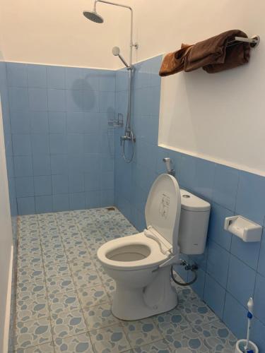 uma casa de banho azul com um WC e um chuveiro em B@B Omaherma Home stay em Boras