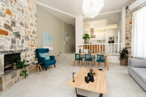 a living room with a couch and a fireplace at Eumelia Iconic Villa, with Heated Pool & Whirlpool, By ThinkVilla in Asigonía