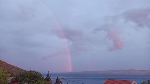 a large body of water with smoke in the sky at Apartments Happy Day in Karlobag