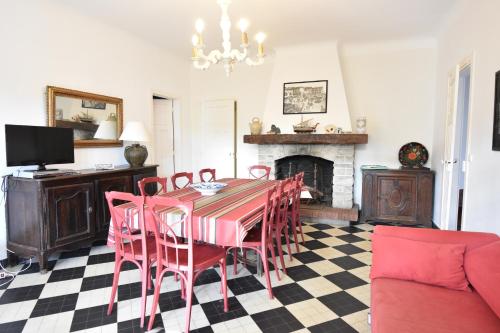 une salle à manger avec une table et des chaises et une cheminée dans l'établissement Mazouna - Hossegor agréable villa des années 60 rénovée sur terrain clos et arboré entre lac et océan, à Soorts-Hossegor