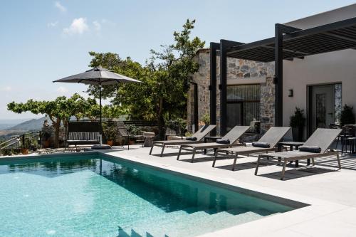 a swimming pool with lounge chairs and an umbrella at Eumelia Iconic Villa, with Heated Pool & Whirlpool, By ThinkVilla in Asigonía
