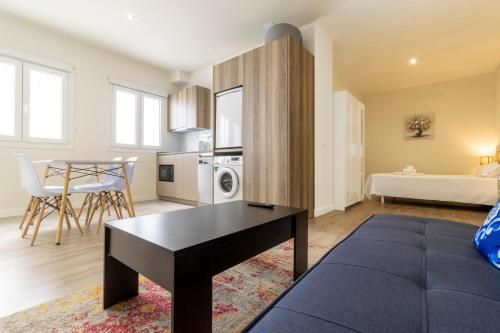 sala de estar con sofá y mesa en Top & Chic Albarizuela Suites - Apartamentos Jerez, en Jerez de la Frontera