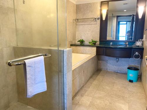 a bathroom with a shower and a tub and a sink at Makam Service Suites Times Square in Kuala Lumpur