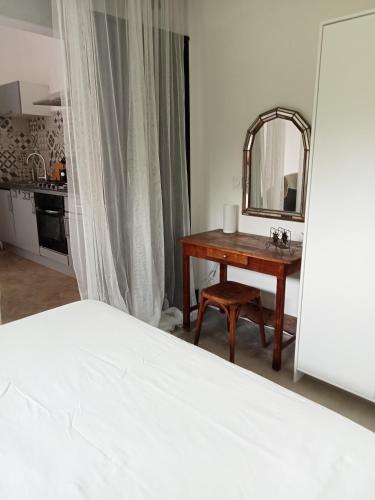 1 dormitorio con cama y mesa con espejo en Yaka, en Saint-Paul