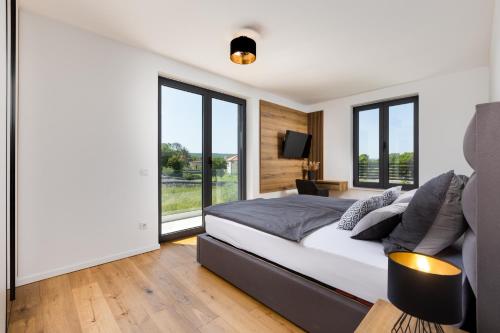 a bedroom with a large bed and large windows at Villa Endless Summer in Sveti Anton