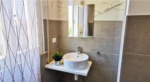 y baño con lavabo blanco y espejo. en Lovely Villa, en Fontane Bianche