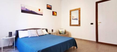 1 dormitorio con cama azul y espejo en Lovely Villa, en Fontane Bianche