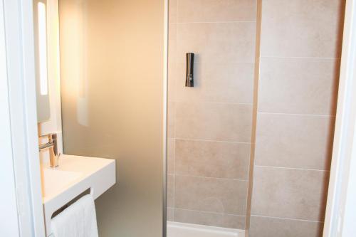 y baño con ducha, aseo y lavamanos. en B&B HOTEL Aix-les-Bains, en Grésy-sur-Aix